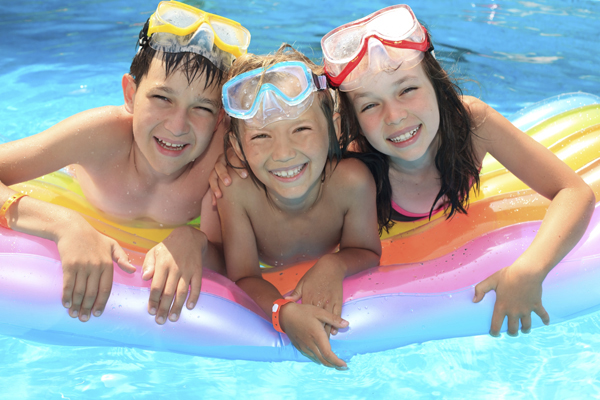 Kids Swimming in a Lonestar Fiberglass Pools Shavano Park Texas having a great time in their private backyard oasis non-Airbnb staycation vacation